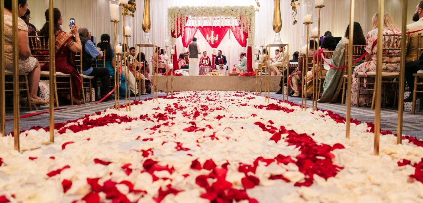 Indian wedding mandap ceremony with a rose petal aisle