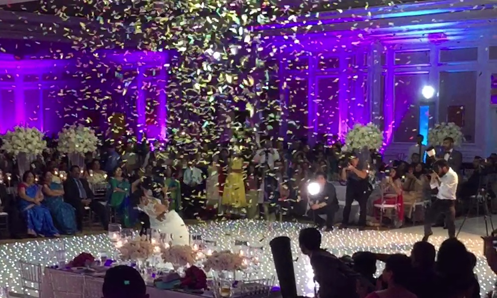 Confetti cannons firing over the dance floor at an Indian wedding reception in Dallas
