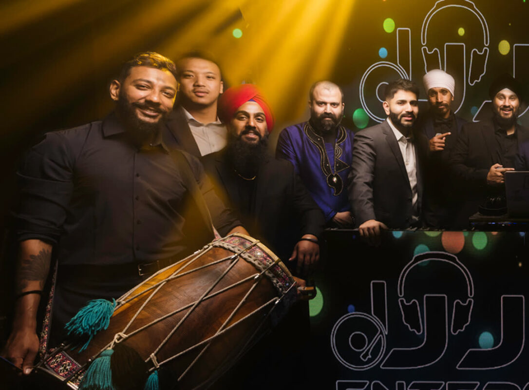 Dhol player with a dhol drum alongside the DJ Jazz Entertainment team at a Dallas Indian wedding